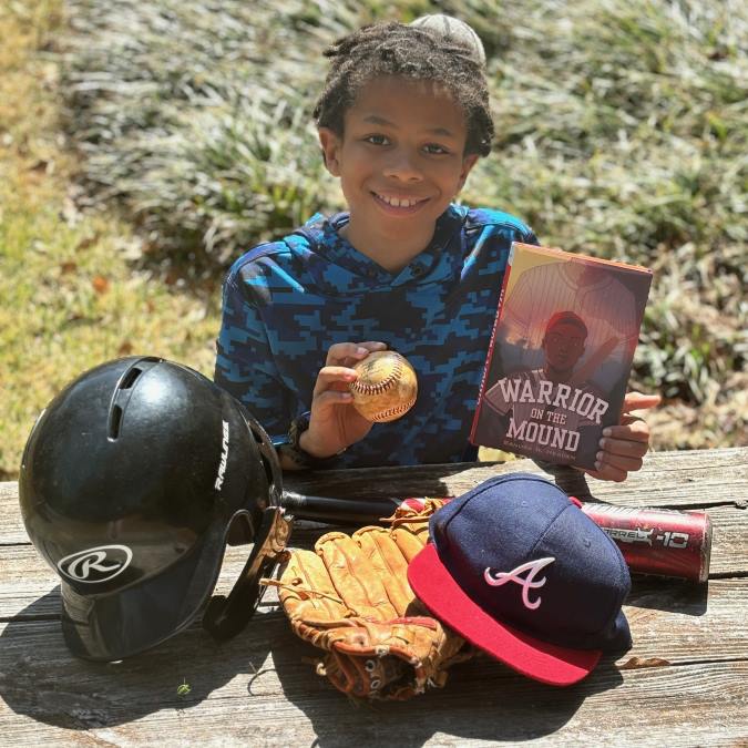 Boy holding Warriors on the Mound book